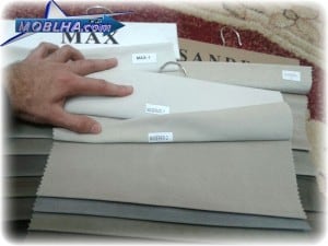 عکس از چند کارلیته و دستی که به کد های پارچه به رنگ روشن پارچه مبلی اشاره میکند